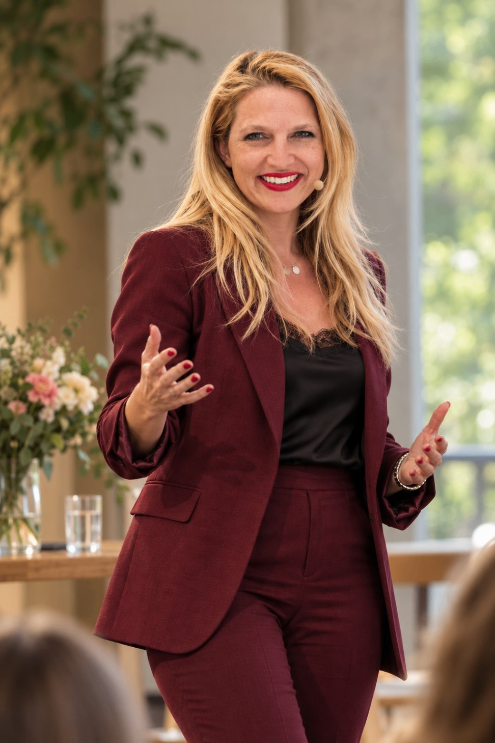 Nathalie Sameli lächelt im bordeauxroten Anzug